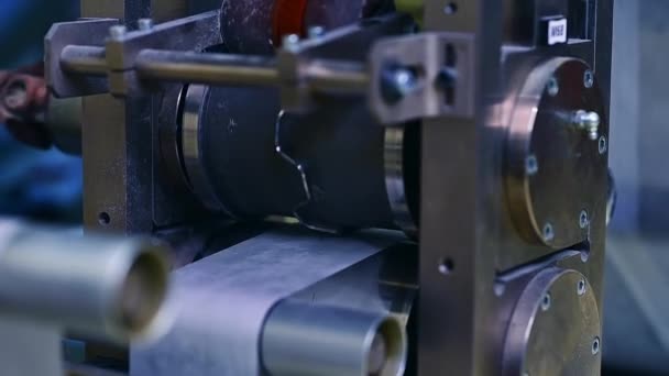 工場でおむつを生産するための技術機器 コンベヤーラインで回転するシャフトおよびローラー クローズアップ — ストック動画