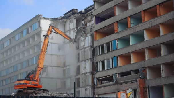 コンパクトなオレンジの取り壊し機械が家を解体しました 自然災害によって破壊された建物の建設 下からの眺め — ストック動画
