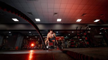 Güçlü fiziksel atletik adam. Spor salonunda üstsüz, kaslı bir adam..