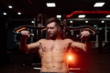 Güçlü, kaslı bir insan. Spor salonundaki kaslı adam zor çalışıyor..