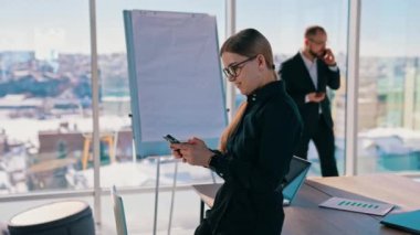 Ofiste telefonu kullanan bir iş kadını. İş kadını iş yerinde cep telefonu kullanıyor