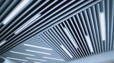 Odada ışık olan beyaz tavan. Bir ofis binası için tasarlanmış tavan lambaları.