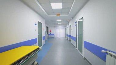 Hastane koridorunda tıbbi yatak. Boş uzun koridoru olan modern bir hastane.