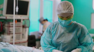 Doktor hastaya ameliyat yapıyor. Hastane ameliyathanesinde koruyucu giysi giyen cerrahi ekip ameliyat yapıyor.