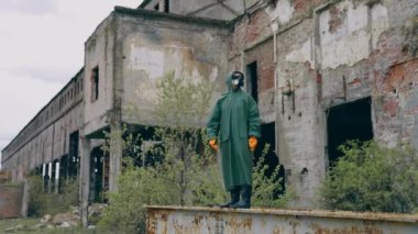 Harabelerde koruyucu maskeli bir adam. Gaz maskesi takan bir adamın dramatik portresi yıkılmış binanın hemen yanında.