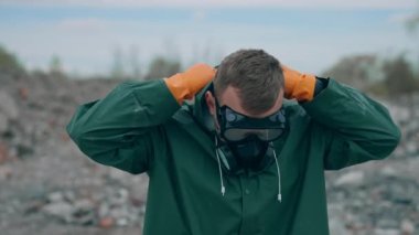 Gaz maskeli bir kıyamet adamı harabeye döndü. Gaz maskeli bir adam portresi ve harap arka planda koruyucu giysiler.