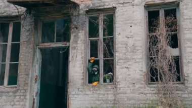 Gaz maskeli adam yıkılmış binada. Radyoaktif ortama karşı koruyucu giysi ve maske giyen adam