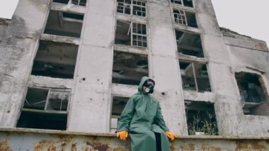 Adam harabelerin arkasında oturuyor. Nükleer kimyasal savaştan sonra takipçi kavramı hayatta kaldı