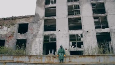Nükleer kimyasal kazadan sonra hayatta kalan. Gaz maskeli adam neredeyse yıkılmış bir bina.