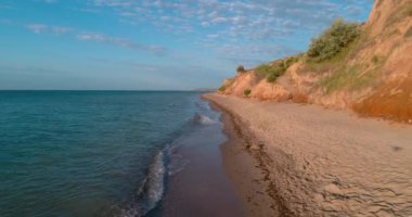 Şarkıcı müzisyen açık havada gösteri yapıyor. Sahildeki mikrofona şarkı söyleyen müzisyenlerin hava görüntüsü