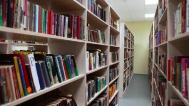 Büyük kitaplığı olan bir kütüphane. Kütüphanede renkli bir kitap duvarı