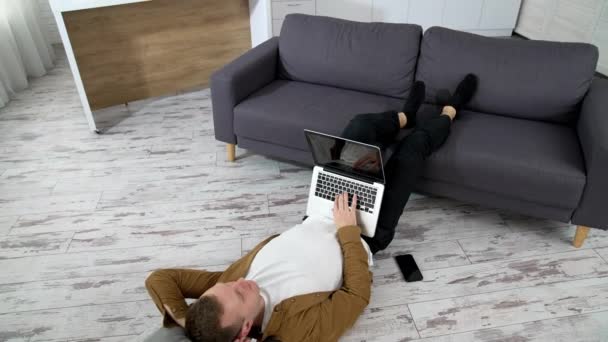 Pria Yang Berbaring Ruang Tamu Anak Muda Menggunakan Laptop Saat — Stok Video