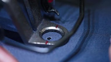 Dikiş fabrikasında çalışan bir terzi. Atölyede dikiş makinesi kullanan kadın terzi.