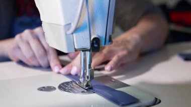 Terzilik yapan kadın eller. Moda tasarım atölyesinde dikiş makinesiyle çalışan terzi.