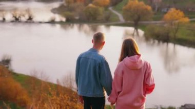 Doğada yürüyen bir çift. Birlikte parkta yürürken el ele tutuşan çiftin arka plan görüntüsü