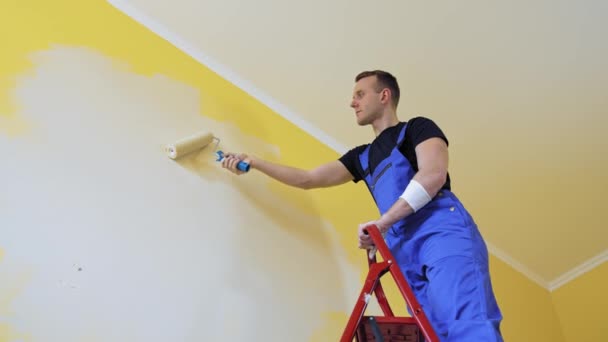 Apartment Redecoration Home Construction Caucasian Man Paints Wall Roller — Stock Video
