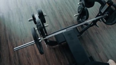 Adam spor salonunda ağırlık kaldırıyor. Göğüs presi yapan profesyonel sporcuların en iyi görüntüsü