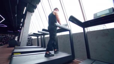 Koşu bandında koşan adam. Spor salonunda spor yapan ve koşu bandında koşan bir sporcu.