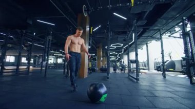 Hardcore Spor Salonu 'nda egzersiz. Sporcu tişörtsüz adam spor salonunda sıkı çalışıyor.