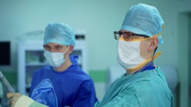 Ameliyat yapan profesyonel kooperatif doktorlar. Bir grup sağlık çalışanı ameliyathanede ameliyat yapıyor.
