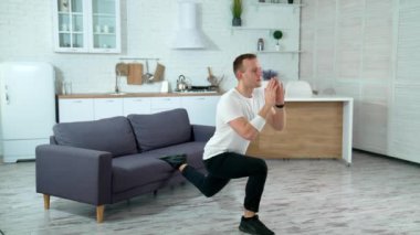 Evde egzersiz yapan bir adam. Genç adam evde spor yapıyor.