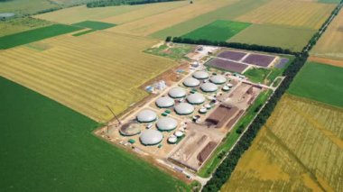Biyogaz tesisinin hava görüntüleri. Yeşil tarlalardaki biyogaz tesisi ve çiftlik üzerinde hava görüntüsü