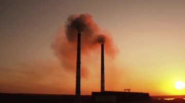 Endüstriyel ekoloji kirliliği. Gün batımında fabrika borularının hava aracı görüntüleri.