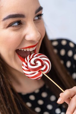 Lolipopun tadını çıkaran kadın. Ağzında lolipop tutan bir kadın.