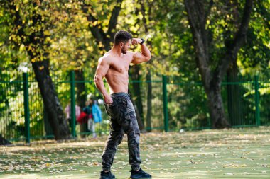 Parkta Tişörtsüz Adam kaykay yapıyor. Parkta kaykayın üstünde üstsüz bir adam.