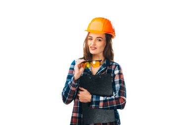 Hard Hat İnşaat Alanındaki Kadın. Sert bir şapka takan ve elinde dosya tutan bir kadın.
