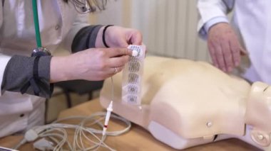 Kalp masajı yapan kuklayı tut. Hastane yatağında bağlı yaşam destek sensörleri olan plastik kukla.