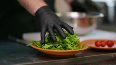 Restoranın mutfağında çalış. Koruyucu eldivenli aşçılar mutfakta yemek hazırlıyor.