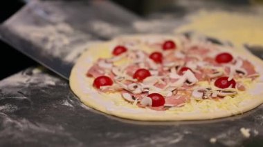Şef pizza pişiriyor. Mutfaktaki restoran şefi geleneksel İtalyan pizzası pişiriyor.