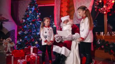 Kardeşler Noel Baba 'ya mektup yazıyor. Mutlu aile Noel Baba 'nın gülüşüyle
