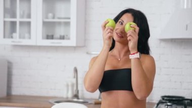 Mutfakta elmayla oynayan mutlu kadın. Mutfakta elmayla oynayan mutlu bir kadın, ev hanımı sağlıklı bir kahvaltı yapar.