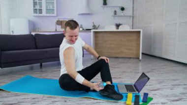 Evde spor egzersizleri var. Bir erkek spor yapmak için ev eşyaları kullanır.