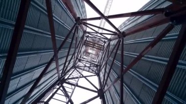 Endüstriyel santraldeki metal kuleler. Gökyüzünde tahıl asansörleri olan modern bir tarım fabrikasının çelik inşaatı.