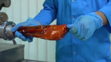 Uzman sosis yapar. Fabrika işçisi özel bir makine kullanarak sosis yapıyor.