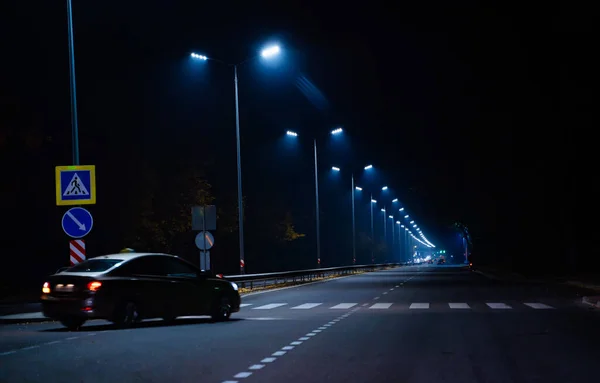 A Serene Night Drive Through the City. A car driving down a street at night
