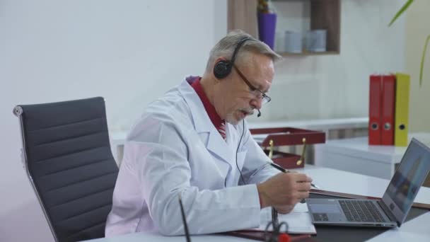 オンラインで患者を予約する医師 遠いビデオ通話を持っている医学ガウンの専門医 リモートコンサルティング — ストック動画