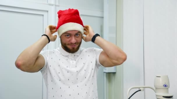 Hombre Que Pone Gorra Navidad Clínica Hombre Sonriente Visita Oftalmólogo — Vídeo de stock