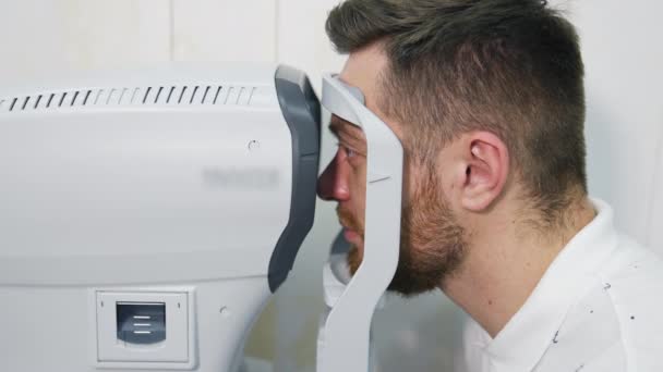Ασθενής Εξετάζει Συσκευή Στην Οφθαλμολογική Κλινική Προφίλ Του Προσώπου Του — Αρχείο Βίντεο