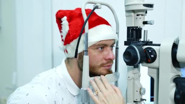 Patient Christmas Cap Ophthalmologist Man Testing His Eyes Clinic Young — Stock Video