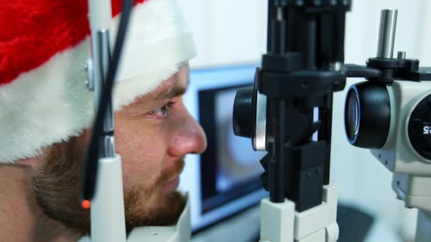 Pacjent Leczący Oczy Klinice Profil Twarzy Mężczyzny Czapce Świątecznej Patrząc — Wideo stockowe