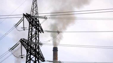 Sigara piposunun arka planında elektrik direği var. Endüstriyel borulardan yayılan zararlı duman. Hava kirliliği.