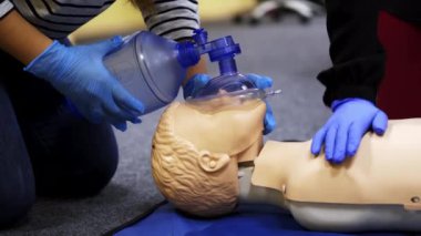 Manikin üzerine eğitim kursu. Uygulayanlar canlandırmada bir kuklayla nefes egzersizi yapıyor. Bir mankene yapılan kalp krizi sırasında basınç.