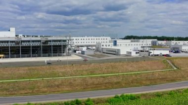 Modern fabrikanın dışı. Mavi gökyüzünün altındaki sanayi binalarının geniş bir bölgesi. Açık havada imalat. Ön manzara. İHA uçuşu.