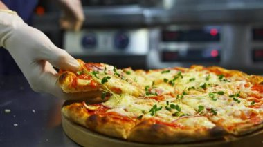 Pizzayı elimle alıyorum. Sıcak, lezzetli pizzalar hazır. Tahta üzerinde pizza. Taze yeşil lahanalı lezzetli pizza. Yakın plan..