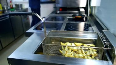 Kızartma makinesinde kızarmış patates hazır. Modern mutfak restoranında patates kızartması pişirdim. Lezzetli çıtır patates. Abur cubur.