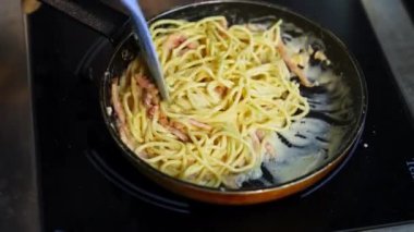 Lezzetli soslu pastırmalı makarna. Kızartma tavasında lezzetli yemekler pişirmek. Şef bir restoranda makarna pişiriyor. Yemek malzemesi. Mutfakta yemek pişirmek. Gurme için pişirilmiş.